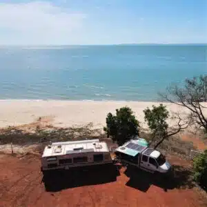 Caravan set up for camping with its pop-top roof open, parked outdoors