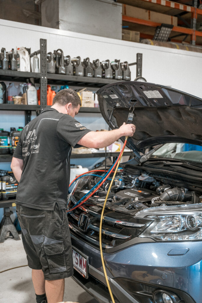 Car undergoing maintenance on its engine in a workshop