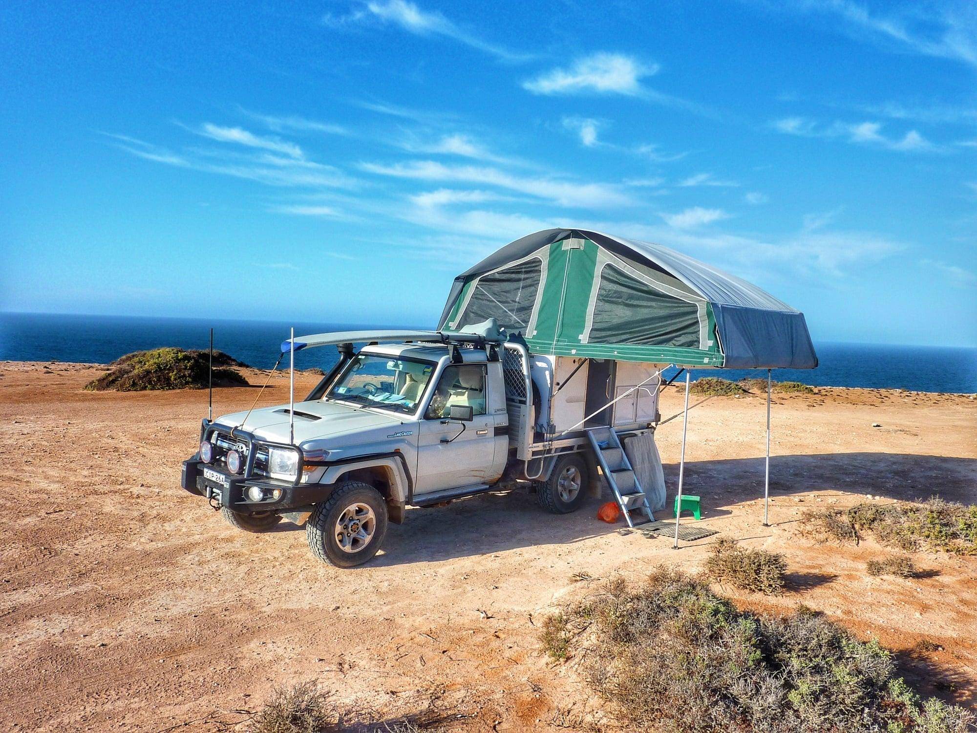 Compact car with a raised pop-top roof, ideal for camping adventures
