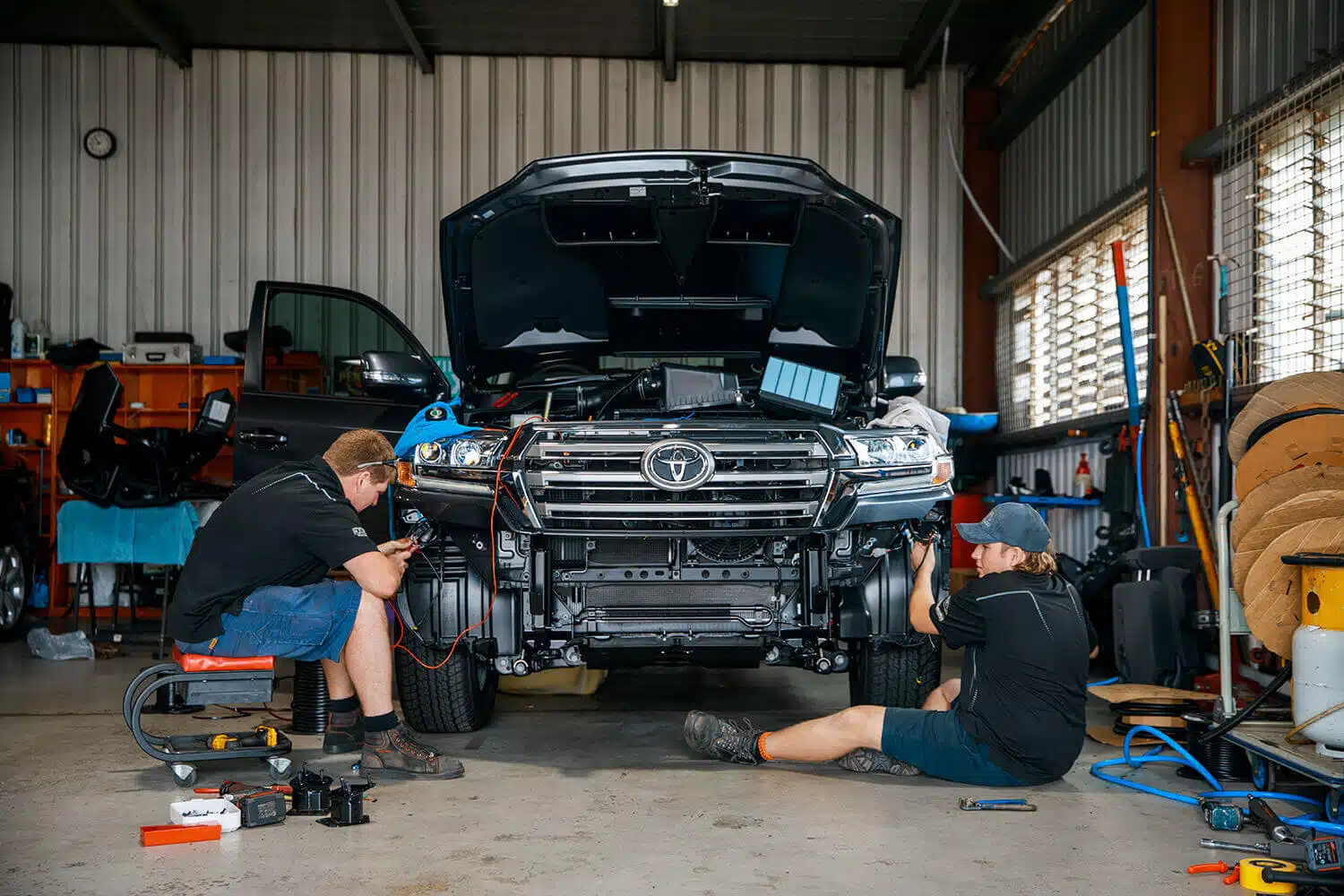 Teamwork makes the dream work: Mechanics collaborating on a car repair