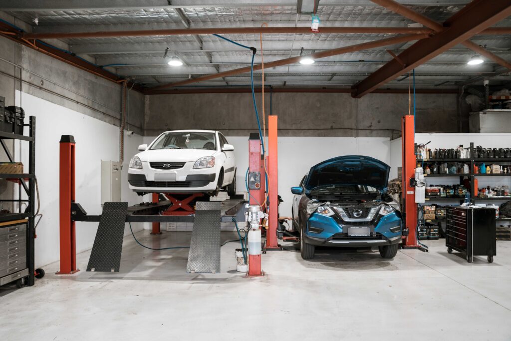 Close-up view of a car engine bay inside a garage, showcasing the vehicle undergoing service.