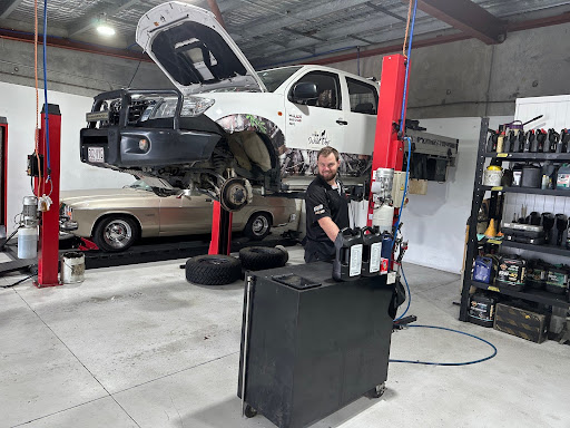 A car being lifted on a hydraulic hoist for servicing